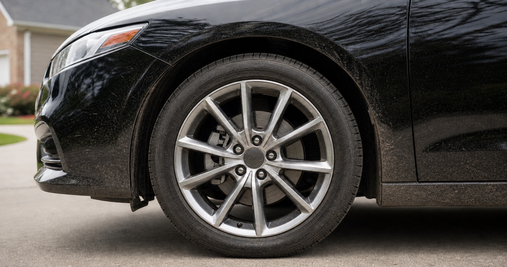Sedan wheel before professional detailing, with visible road grime and brake dust.