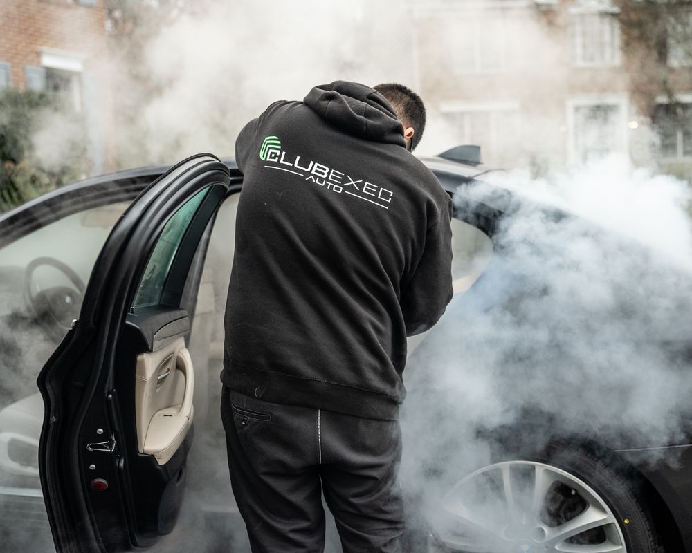 ClubExec technician steam cleaning a vehicle interior.
