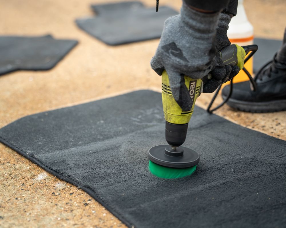 Vehicle floor mat being machine scrubbed.